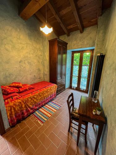 um quarto com uma cama e uma mesa num quarto em Old Village Linda - Tra Lunigiana & Cinque Terre em Comano