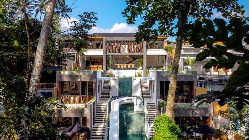 a building with a swimming pool and trees at Villa Santa Monica by BaliSuperHost in Ubud