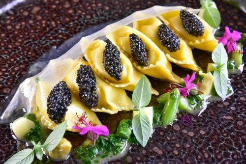 a plate of food with blackberries and flowers on it at Kempinski Hotel Grand Arena Bansko in Bansko