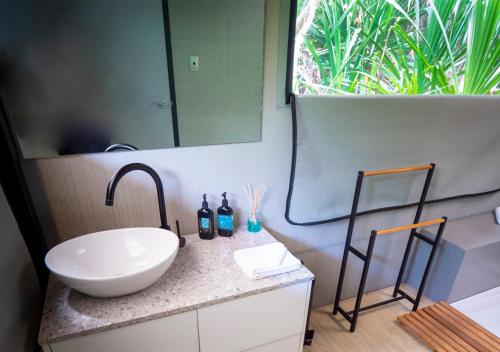 ein Badezimmer mit einem weißen Waschbecken und einem Spiegel in der Unterkunft Swell Lodge in Flying Fish Cove