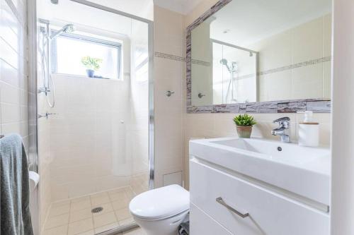 a bathroom with a sink and a toilet and a shower at MikaLex - Walking distance from the beach! in Nelson Bay