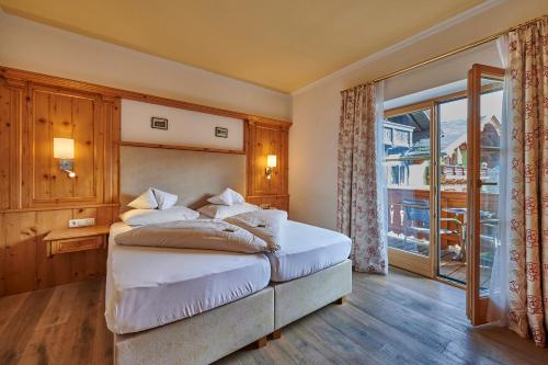 a bedroom with a bed and a large window at Hotel Zimmerbräu in St. Wolfgang