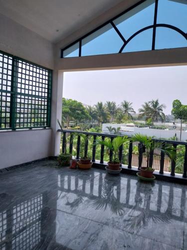 Camera dotata di balcone con piante e finestre. di Mirnalini Homestays a Mamallapuram