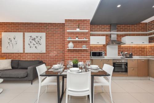 a kitchen and dining room with a table and chairs at Easy Stay - The Vantage Rosebank in Johannesburg