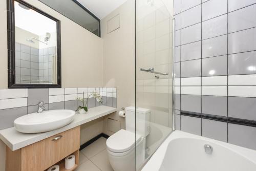 a bathroom with a sink and a toilet and a shower at Easy Stay - The Vantage Rosebank in Johannesburg