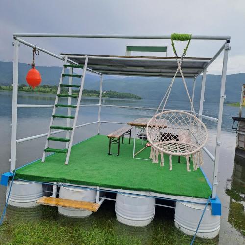 a swing on a boat with a table and a ladder at Vikendica Bruše in Jaklići