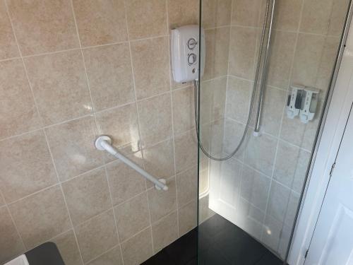 La salle de bains est pourvue d'une douche et d'une porte en verre. dans l'établissement Holbury B&B, à Southampton