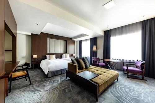 um quarto de hotel com uma cama e um sofá em The Royal Park Hotel Kyoto Sanjo em Quioto