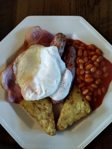 a plate of breakfast food with an egg and beans at The Garden Apartment in Enniskillen