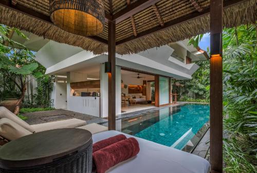 an outdoor living room with a swimming pool and a villa at Bisma Eight Villas in Ubud