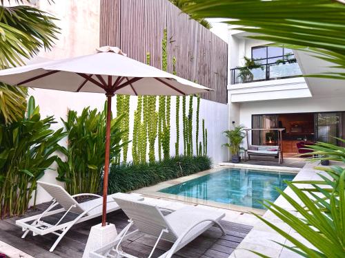 um guarda-sol e cadeiras junto a uma piscina em LINDT - Bali Invest Club em Dalung