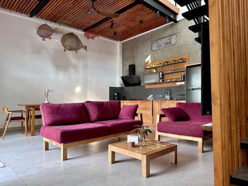 uma sala de estar com sofás roxos e uma mesa em LINDT - Bali Invest Club em Dalung