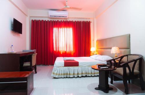 Hotel Golden Inn Chattagram Ltd في شيتاغونغ: غرفة فندقية بسرير وستارة حمراء