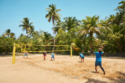 a group of people playing volleyball on a beach at ROBINSON KHAO LAK in Khao Lak