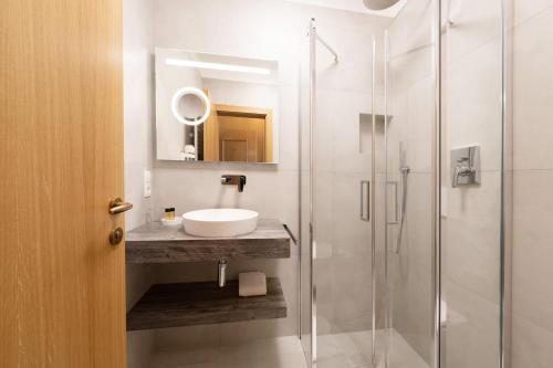 a bathroom with a sink and a shower at PENSION KLUGHAMMER in Caldaro