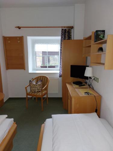 a bedroom with a desk and a bed and a chair at Mini-1-Raum-Apartment mit eigenem Eingang in Bad Doberan