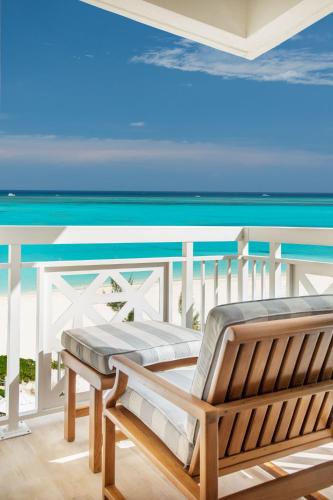 a bench on a balcony overlooking the ocean at Alexandra Resort - All-Inclusive in Grace Bay