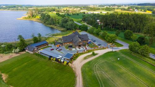 an aerial view of a large house on the water at Łabędź Hotel Karczma in Iława