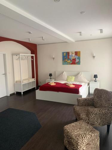 a bedroom with a bed and a couch and a chair at Gästehaus "Auszeit" in Burgschwalbach
