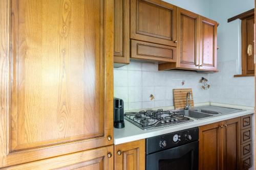 a kitchen with wooden cabinets and a stove top oven at Il Serrino 5 in Pistoia
