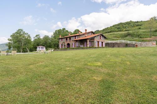 an old house on top of a grass field at Il Serrino 5 in Pistoia