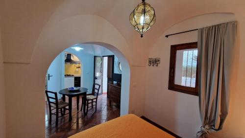 a bedroom with an archway with a table and chairs at I Dammusi di Punta Karace in Tracino