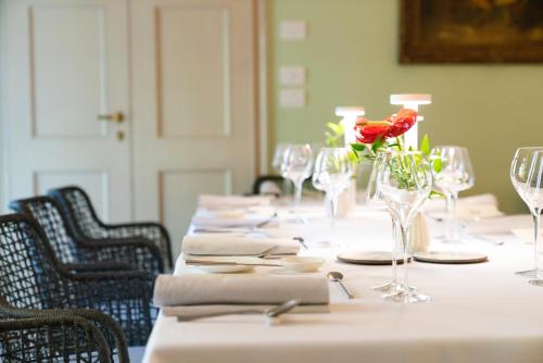 a table with glasses and a red rose on it at Villa Abbondanzi Resort in Faenza