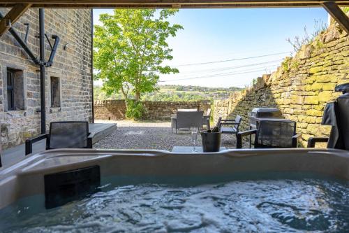 a hot tub in the backyard of a house at Meadow Barn in Rishworth