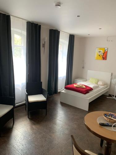 a bedroom with a bed and a table and chairs at Gästehaus "Auszeit" in Burgschwalbach
