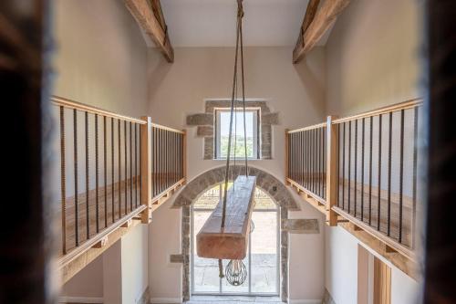 a hallway with a staircase with a window and a chandelier at Meadow Barn in Rishworth