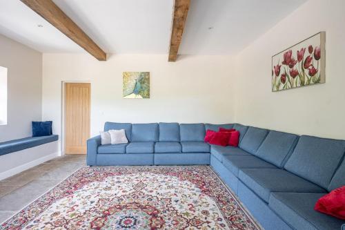 a living room with a blue couch and a rug at Meadow Barn in Rishworth
