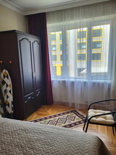 sypialnia z łóżkiem i dwoma oknami w obiekcie Apartment Amest w mieście Batumi