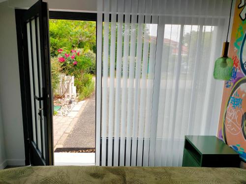 a sliding glass door with a view of a yard at Chambre Street Art in Capbreton