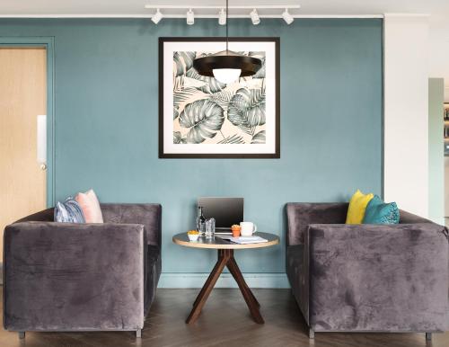 a living room with two chairs and a table at Holiday Inn Lincoln by IHG in Lincoln