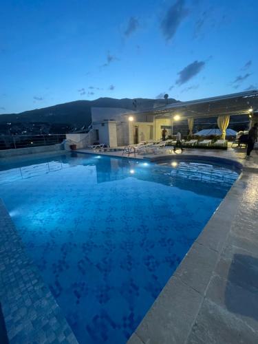 a large swimming pool at night at Delora Hotel and Suites in Chtaura