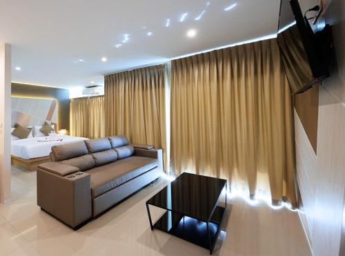 a living room with a couch and a bed at La Vista Patong Hotel in Patong Beach