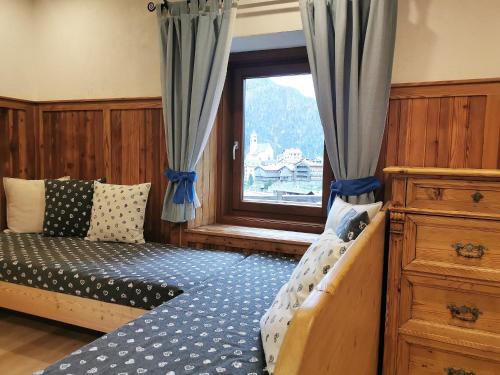 1 dormitorio con cama y ventana en Cesa da Riz, en Colle Santa Lucia