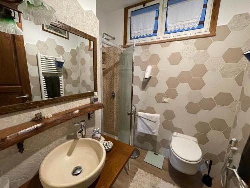 a bathroom with a sink and a toilet and a mirror at Luminoso appartamento al mare in Celle Ligure
