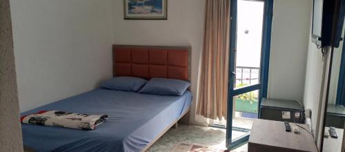 a small bedroom with a bed and a window at Caglayan pansiyon in Bodrum City