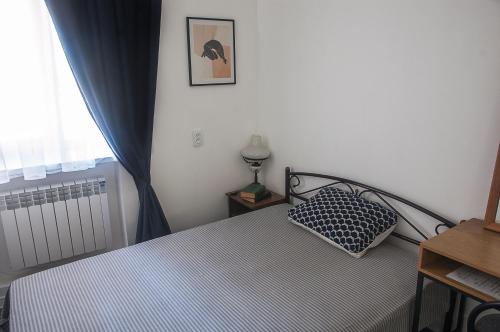 um quarto com uma cama com uma almofada e uma janela em Садовая-Дерибасовская em Odessa