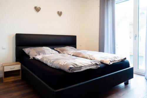 a black bed with pillows on it in a room at Ferienwohnung Epting in Kappelrodeck