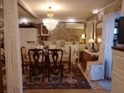a dining room with a table and chairs and a chandelier at Studio Penelope in Kerasochórion