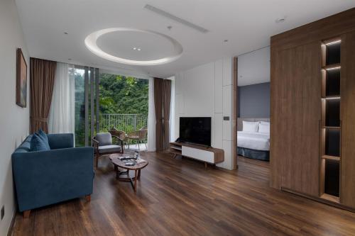 a living room with a couch and a tv and a bed at Flamingo Resort Cat Ba in Cat Ba