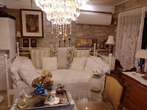 a living room with a white couch and a chandelier at Studio Penelope in Kerasochórion