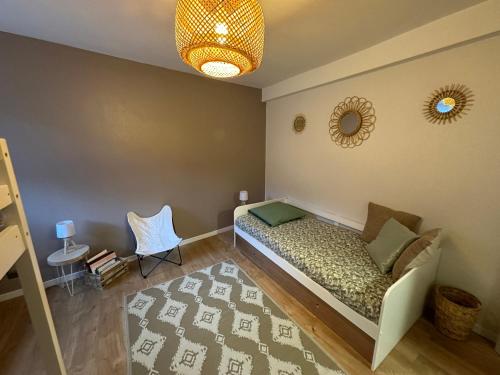 une chambre avec un lit, une chaise et un miroir dans l'établissement Le cocon de Marckolsheim proche Europapark, à Marckolsheim