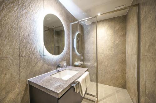 uma casa de banho com um lavatório e um espelho em Browndot Hotel Gwangju Pungam em Gwangju