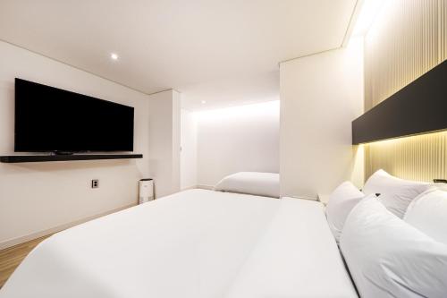 a hotel room with a bed and a flat screen tv at Browndot Hotel Gwangju Pungam in Gwangju
