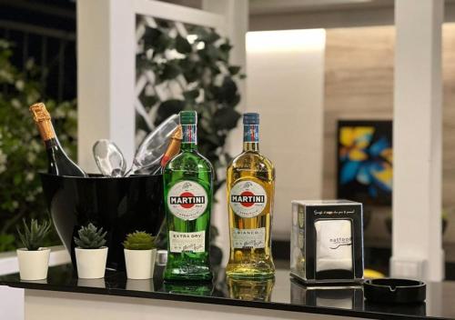 two bottles of alcohol on a table with a clock at Palazzo Firenze in Naples