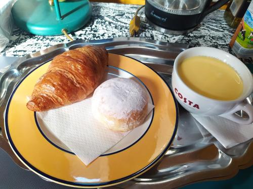 a plate with a pastry and a cup of coffee at Cuki Apartment in Budapest