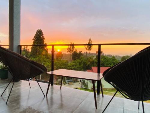 a balcony with a table and chairs and a sunset at Family Hotel Sunset in Chakvi